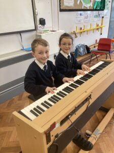 Two children playing the keyboard