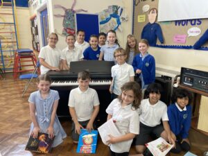 School-children around an upright pianio
